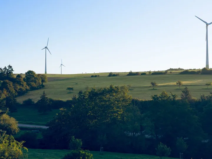 Scenic view of wind turbines on grassy hills in