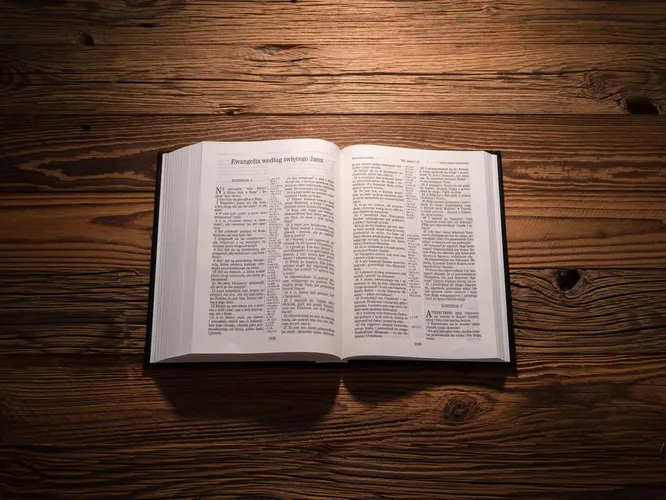 Open Bible on a wooden table under warm light