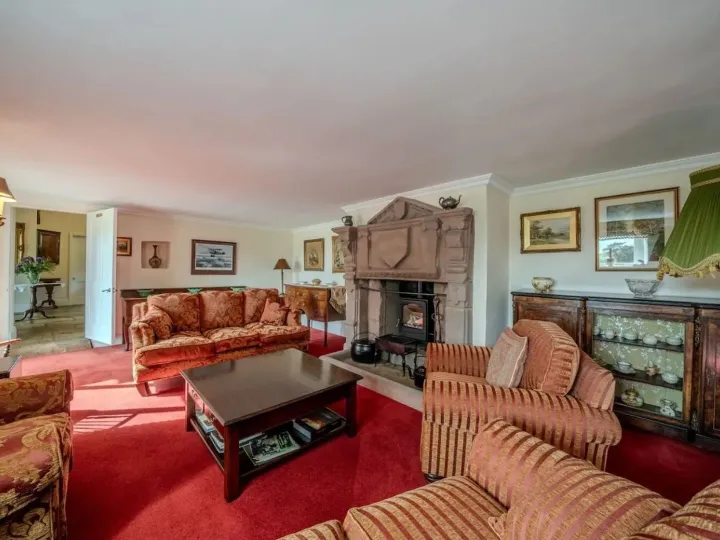 The lounge with sofas around the 18th century fireplace and log burner