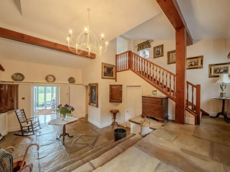 The flagstone hallway with elegant staircase and chandelier