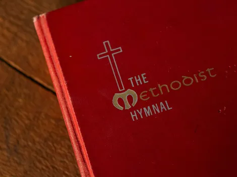 A Methodist hymn book resting on a wooden table