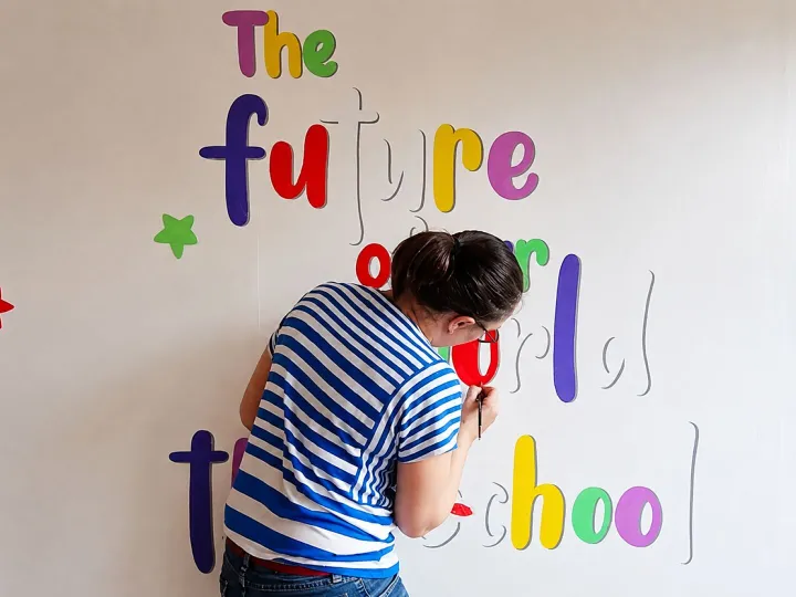 Naomi hand lettering at her studio desk surrounded by paints and brushes