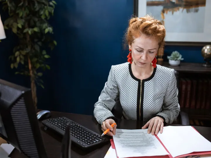 A focused woman working on paperwork in a modern