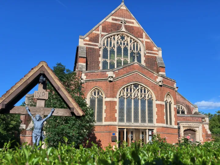 A red brick church building under a blue sky