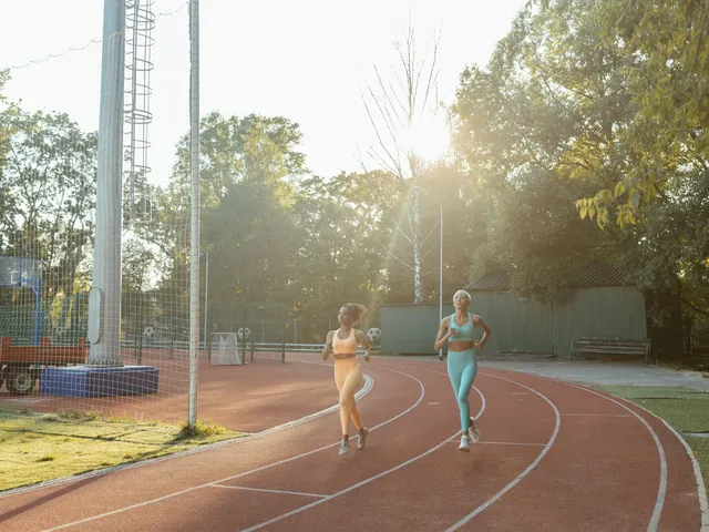 Two runners training on an outdoor track