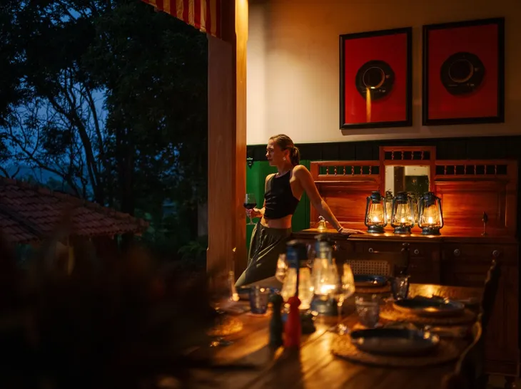 A guest by the antique dresser as the dining room is lit at Peacock Hill Sigiriya