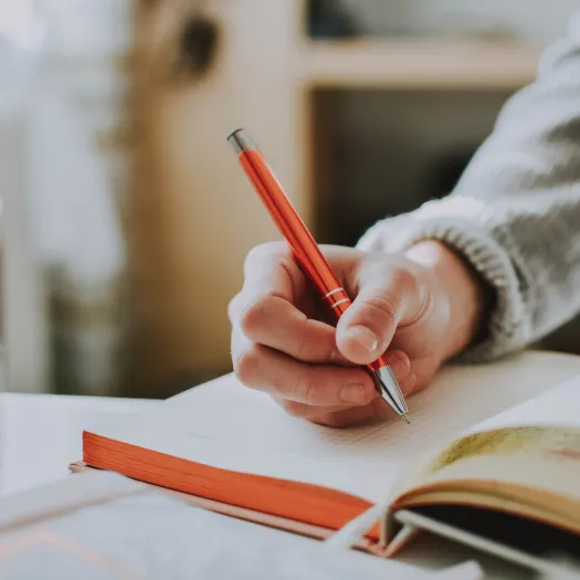 Person Holding Orange Pen
