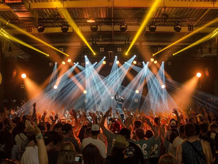 Concert crowd before a lit stage
