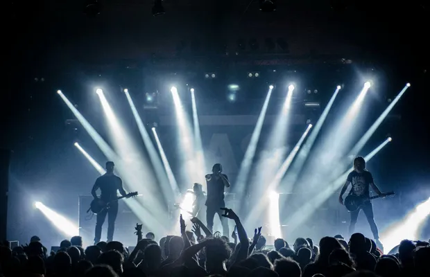 Energetic live concert with musicians performing on stage, engaging the crowd with vibrant lighting effects.