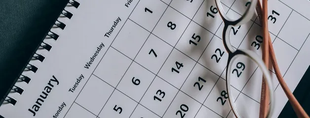 A close-up of a January calendar with eyeglasses