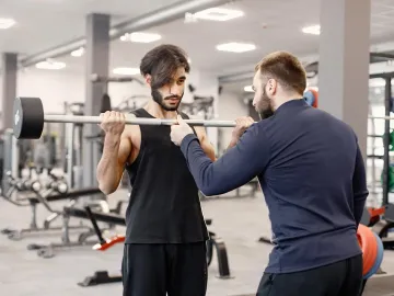 Indian man doing excercisses on special equipment at gym wit