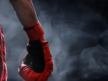 Red boxing glove in smoky light
