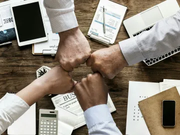 Teamwork hands joined across a desk