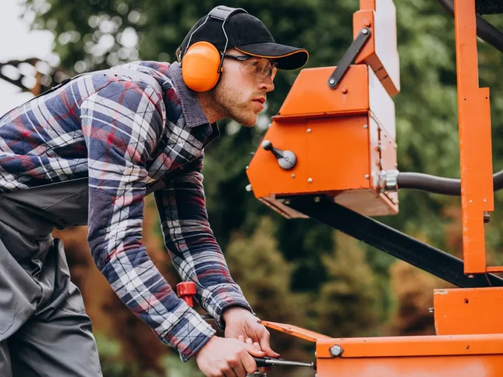 Carpenter working on a sawmill on a wood manufactu