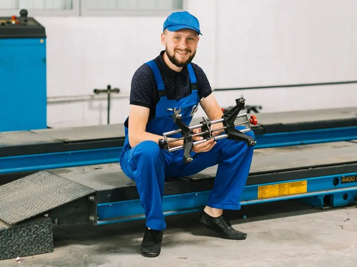Technician with car detail at garage