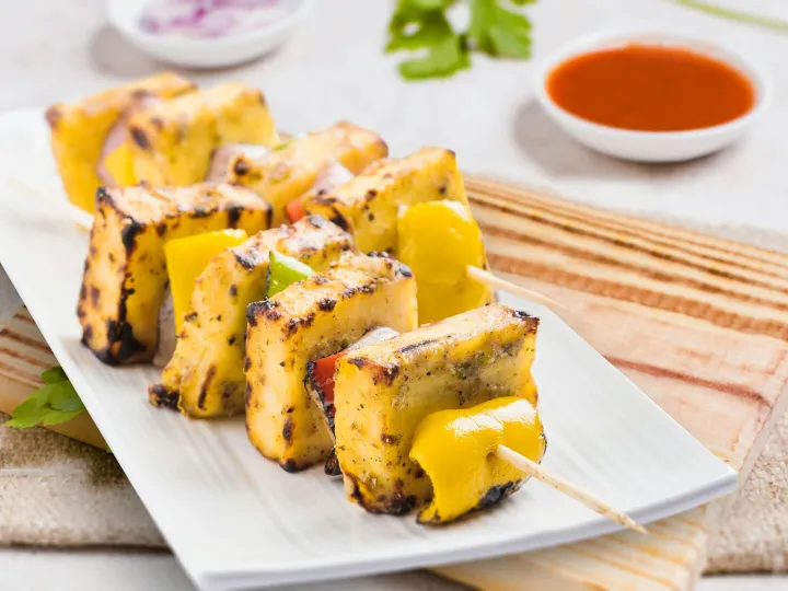 Tasty grilled paneer tikka skewers served on a