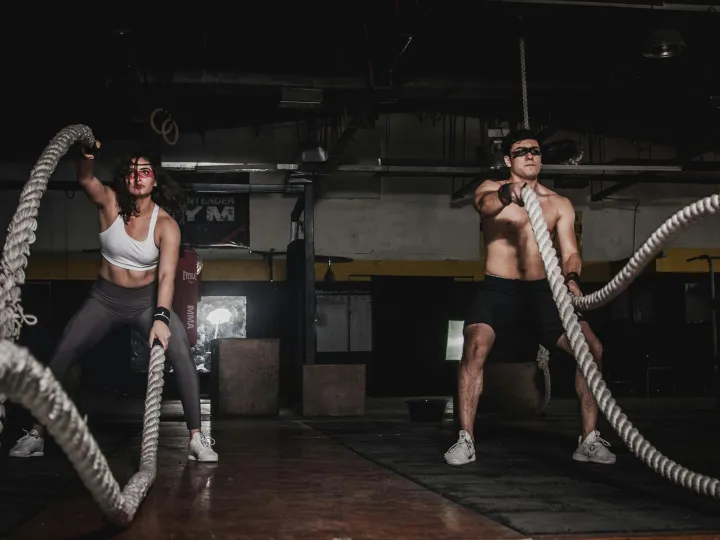 Two people engage in a powerful indoor battle rope