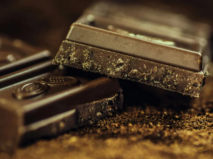 Macro shot of rich dark chocolate bars sprinkled